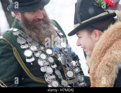 Traditionell gekleidete Männer und Frauen reiten einen Wagen an die traditionelle Leonhardifahrt Prozession durch eine Wiese auf dem Kalvarienberg in Bad Tölz, Deutschland, 07 Novmeber 2016. Die Prozession zu Ehren von St. Leonhard wird aufgeschoben, wenn der 6. November auf einen Sonntag fällt. Die prächtige Kutschen sind durch die Isar-Stadt am Montag gezogen. Foto: PETER KNEFFEL/dpa Stockfoto