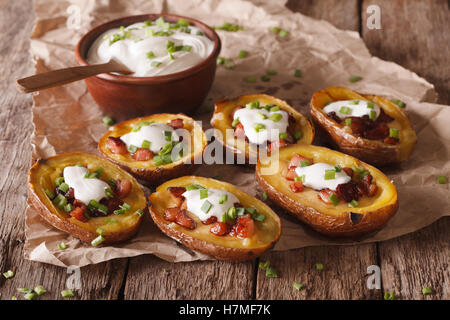 Rustikale Kartoffelschalen mit Käse, Speck und Sauerrahm Nahaufnahme auf dem Tisch. horizontale Stockfoto