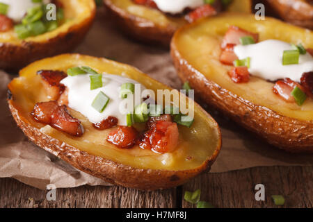 Gefüllte Kartoffelschalen mit Käse und Speck Nahaufnahme auf dem Tisch. Horizontal, rustikal Stockfoto