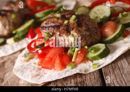 Frikadellen mit frischem Gemüse auf eine Tortilla Nahaufnahme auf dem Tisch. horizontale Stockfoto