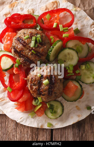 Frikadellen mit frischem Gemüse und Fladenbrot Nahaufnahme auf dem Tisch. vertikale Ansicht von oben Stockfoto