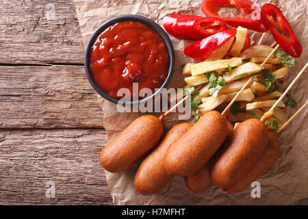 Corndogs, Pommes frites, Pfeffer und Ketchup auf den Tisch. Horizontale Ansicht von oben Stockfoto