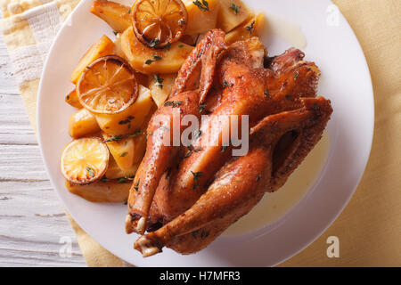 Zitronen-Huhn mit Kartoffeln hautnah auf einem Teller auf den Tisch. horizontale Ansicht von oben Stockfoto