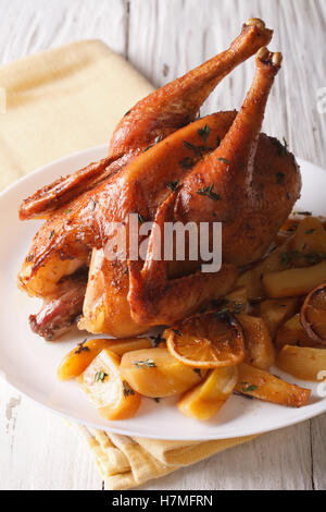 Gesamte gebackenes Huhn mit Zitrone und Thymian Nahaufnahme auf einem Teller auf den Tisch. vertikale Stockfoto