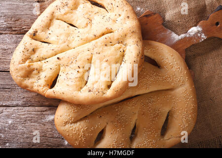 Fugasse französisches Brot mit Sesam-Samen und Kräuter-Closeup auf dem Tisch. Horizontale Ansicht von oben Stockfoto