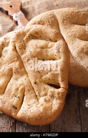 Traditionelle französische Brot Fugasse mit Sesam-Samen und Kräuter Makro auf dem Tisch. vertikale Stockfoto