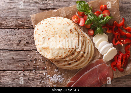 Italienische Piadina flaches Brot, Schinken, Käse und Gemüse close-up auf dem Tisch. horizontale Ansicht von oben Stockfoto