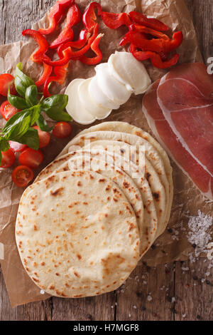 Italienische frisch gebackene Piadina mit Nahaufnahme Zutaten auf den Tisch. vertikale Ansicht von oben Stockfoto