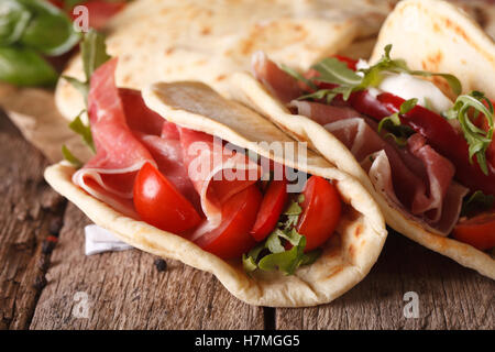 Italienische Piadina Fladenbrot gefüllt mit Schinken und Gemüse Nahaufnahme auf dem Tisch. horizontale Stockfoto