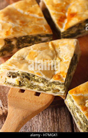 Griechischer Kuchen mit Spinat und Käse Spanakopita close-up auf einem Tisch. Vertikal Stockfoto