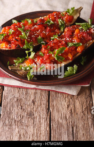 Türkischen Imam Bayildi halbiert gebackene Aubergine mit Gemüse Nahaufnahme auf einer Platte. vertikale Stockfoto