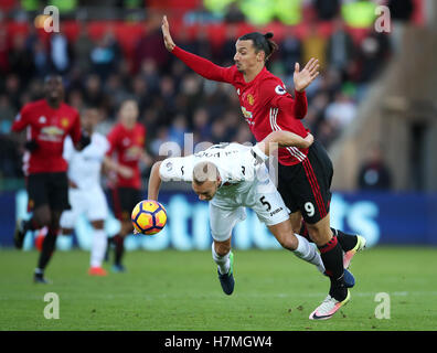 Swansea City Mike van der Hoorn (links) und Manchester United Zlatan Ibrahimovic in Aktion während der Premier League match bei der Liberty Stadium, Swansea. Stockfoto