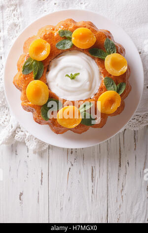 Savarin französischen Dessert mit Aprikosen und Sahne. vertikale Ansicht von oben Stockfoto