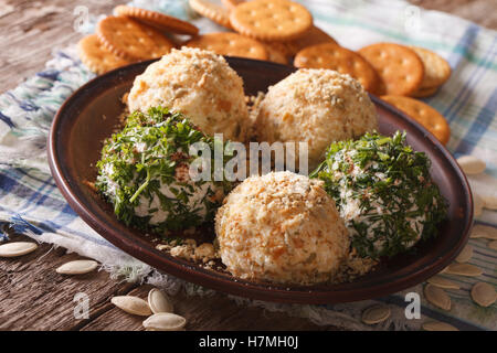 Ziegenkäse-Kugeln mit Crackern, Kräutern und Kürbiskernen Nahaufnahme auf einer Platte. horizontale Stockfoto