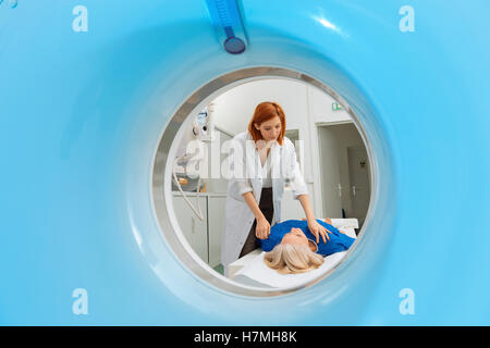 Arzt, die Vorbereitung eines Patienten auf dem Scanner-Zimmer Stockfoto
