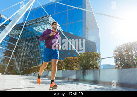 Athlet mit Kopfhörern laufen in der Stadt Stockfoto
