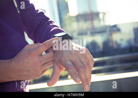 Fitness-Läufer-Mann Überprüfung Herzfrequenz mit Uhr und Trainer bei Outdoor-Trail-running-Training Stockfoto