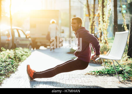 Läufer tun einige Trizeps Dips auf einer Bank Stockfoto