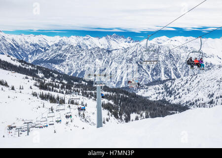 Skifahrer im Sessellift genießen atemberaubende Blick zum Bayerischen Alpen, Fellhorn, Oberstdorf, Deutschland Stockfoto