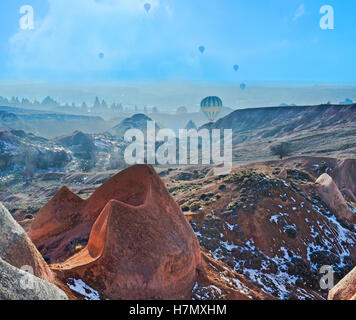 Die Ballons steigen hinter dem Rosental und machen einen Flug über die bekannten kappadokischen Felsformationen, Türkei. Stockfoto