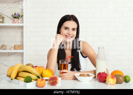 Schöne Frauen gibt es mit reiner Haut im Gesicht, an einem Tisch sitzen und frühstücken. Asiatische Frau gesunde Ernährung beim Frühstück. Obst, Müsli und Milch. Stockfoto