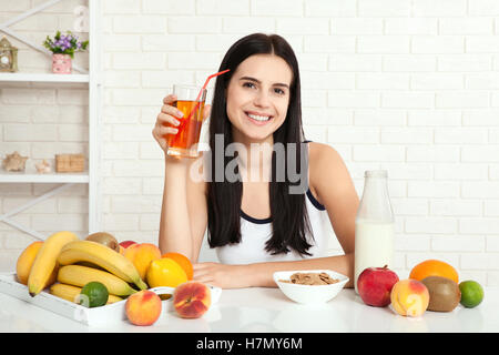 Schöne Frauen gibt es mit reiner Haut im Gesicht, an einem Tisch sitzen und frühstücken. Asiatische Frau gesunde Ernährung beim Frühstück. Obst, Müsli und Milch. Stockfoto