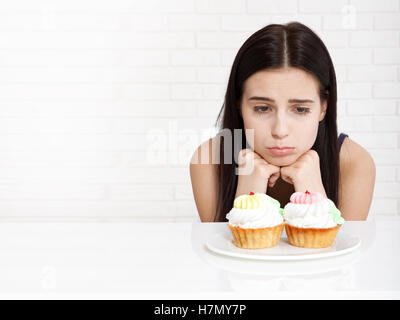 Frau mit Kuchen Nahaufnahme Gesicht. Schöne Frauen leider befasst sich mit Kuchen. Asiatische Frau. Selektiven Fokus. Stockfoto