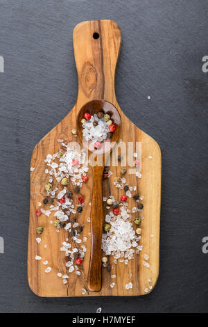 Verschiedene Arten von verstreuten Holzlöffel auf Schneidebrett Olivenöl, Salz und Pfeffer Stockfoto