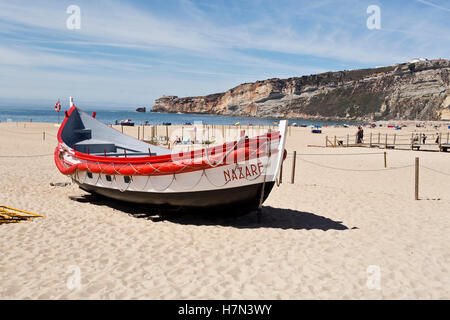 Blick auf die bunten traditionellen Fischerboote am Strand von Fischen Dorf von Nazare, Portugal Stockfoto