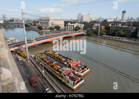 Manila, Philippinen - 20. Februar 2016: Pasig River mit Bunker Lastkähne und mit The Manila Central Post Office Stockfoto