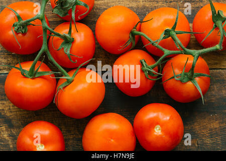 Tomaten mit Niederlassung auf einem hölzernen rustikalen Hintergrund Stockfoto