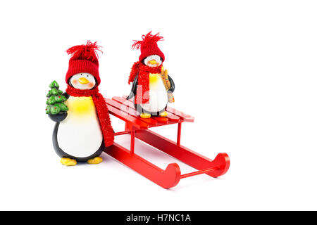 Mutter und Kind Pinguin mit Schlitten und Weihnachtsbaum isoliert auf weißem Hintergrund Stockfoto