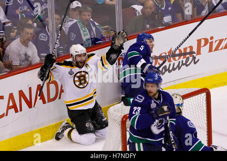 15. Juni 2011; Vancouver, BC, Kanada; Boston Bruins Zentrum Patrice Bergeron (links) feiert nach einem Short-handed Tor vorbei an Vancouver Canucks Verteidiger Christian Ehrhoff (5), Verteidiger Alexander Edler (23) und Torhüter Roberto Luongo (unten rechts) in der zweiten Periode von sieben Spielen der 2011 Stanley Cup-Finale in der Rogers Arena.  Boston besiegt Vancouver 4-0. Stockfoto