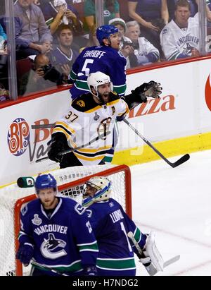 15. Juni 2011; Vancouver, BC, Kanada; Boston Bruins Zentrum Patrice Bergeron (links) feiert nach einem Short-handed Tor vorbei an Vancouver Canucks Verteidiger Christian Ehrhoff (5), Verteidiger Alexander Edler (23) und Torhüter Roberto Luongo in der zweiten Periode von sieben Spielen der 2011 Stanley Cup-Finale in der Rogers Arena. Stockfoto