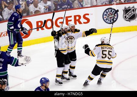 15. Juni 2011; Vancouver, BC, Kanada; Boston Bruins-Zentrum von Patrice Bergeron (links) feiert mit Gregory Campbell (Mitte) und Verteidiger Johnny Boychuk (55) nach ein Tor Short-handed vorbei an Vancouver Canucks Verteidiger Christian Ehrhoff (5) in der zweiten Phase des Spiels sieben von 2011 Stanley Cup-Finale in der Rogers Arena center. Stockfoto