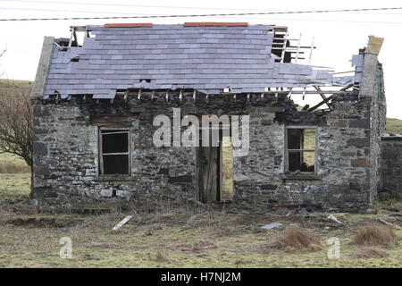 Zerfallendes altes verfallendes Bauernhaus mit Steinmauern in Ruinen mit beschädigtem Schieferdach, verlassen in Irland, in der Nähe von St. John's Point, County Donegal, Stockfoto