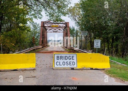 Barrieren und ein Schild Warnung Brücke geschlossen an jedem Ende eine alte Fachwerkbrücke über Walnut Creek in der Nähe von Washington, Oklahoma, USA. Stockfoto