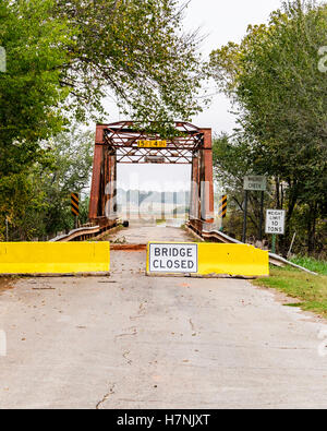 Barrieren und ein Schild Warnung Brücke geschlossen an jedem Ende eine alte Fachwerkbrücke über Walnut Creek in der Nähe von Washington, Oklahoma, USA. Stockfoto