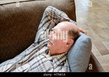 Älterer Glatzenbildung kaukasischen Mann mit einem Schnurrbart ein Nickerchen auf der Couch. Oklahoma, USA. Stockfoto