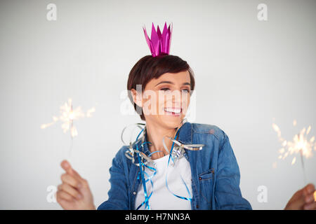 Zwei Feuerwerke statt von einer jungen Frau Stockfoto