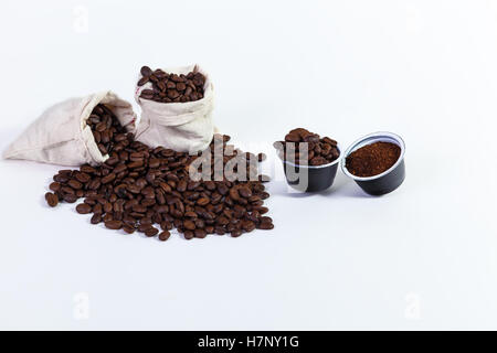 Kapseln von gemahlenem Kaffee für Kaffee, geröstete Kaffeebohnen in einem Lappen-Beutel, gerösteten Kaffeebohnen auf weißem Hintergrund. Stockfoto