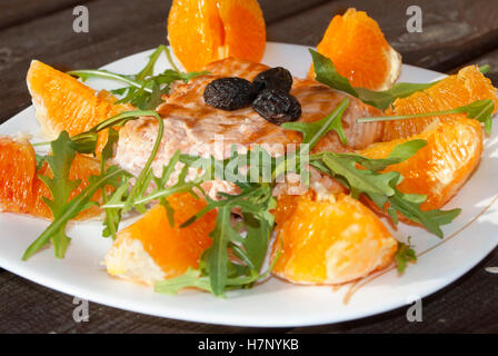 Gebratener Lachs mit Orange sauce, Oliven und Rucola Stockfoto