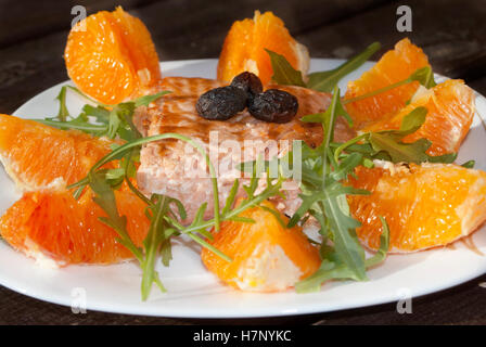 Gebratener Lachs mit Orange sauce, Oliven und Rucola Stockfoto