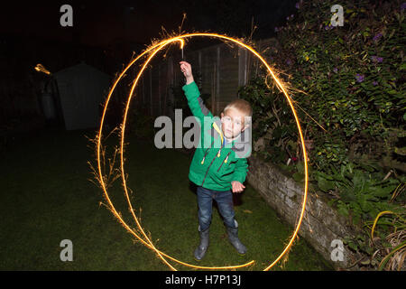 Junge (5 Jahre) im Vorort Hofblick mit handgeführten Feuerwerk Typ "Wunderkerze" Bonfire Night oder traditionell Kerl Fawkes Nacht. Stockfoto