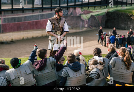 Chester, UK. 26. Januar 2016. Schülerinnen und Schüler sitzen im römischen Amphitheater in Chester, Hände erhoben Beantwortung eine Frage. Stockfoto