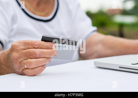 ältere Dame macht einen Kauf über das Internet mit einer Kreditkarte Stockfoto