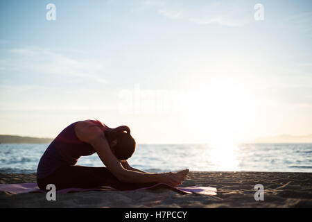 Frau, die Durchführung von Yoga am Strand Stockfoto