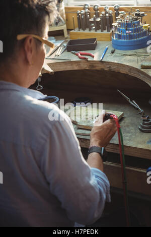 Handwerkerin mit Lötlampe Stockfoto