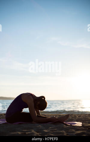 Frau, die Durchführung von Yoga am Strand Stockfoto