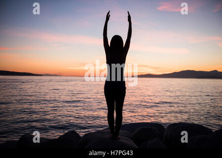 Frau, die Durchführung von Yoga auf Felsen Stockfoto